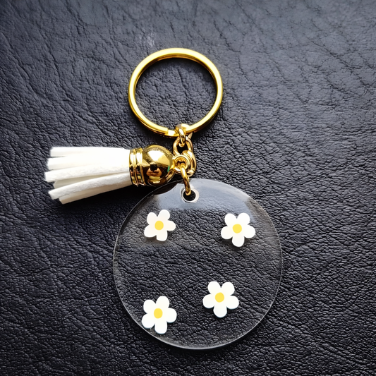 Porte-clés personnalisé rond en acrylique – Prénom doré avec fleurs marguerites et pompon élégant